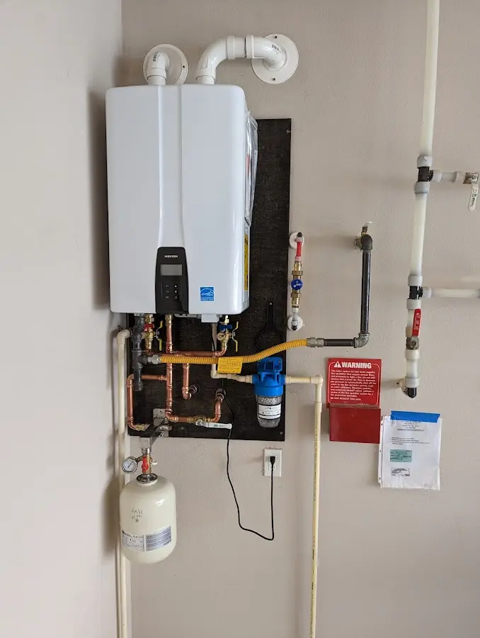 Professional plumber installing copper piping in a Magee home